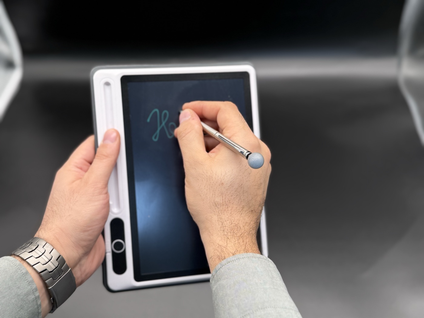 Hands writing on a tablet with a stylus
